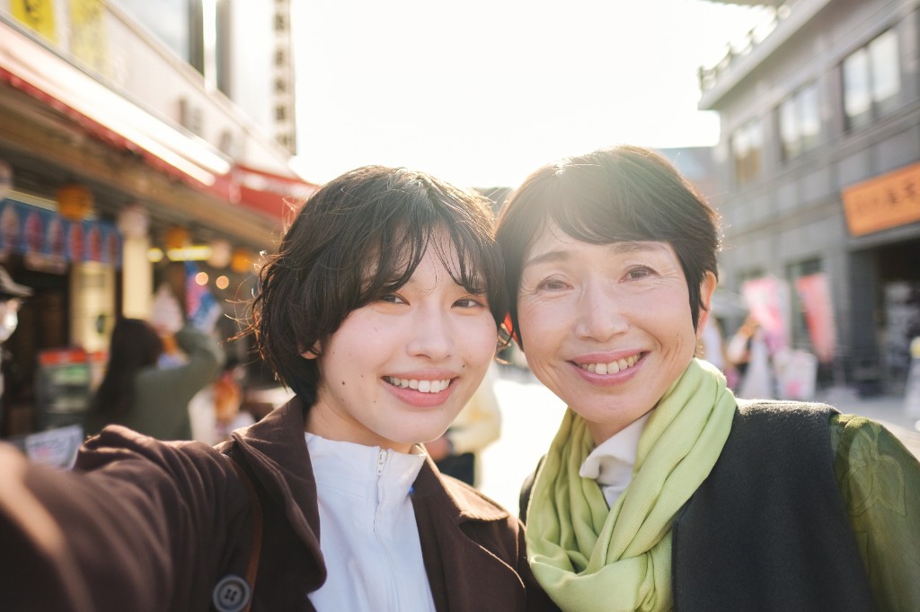 友人と街中で笑顔で過ごす女性